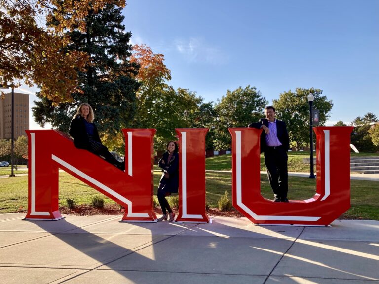 NIU sign on campus with Maria, Chelsea, and Doug